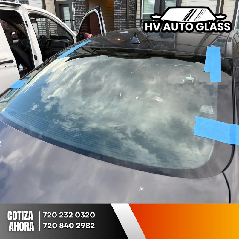Freshly installed windshield taped while the adhesive cures during a mobile appointment