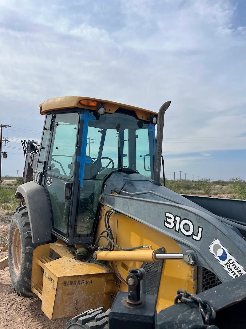 John Deere 310J backhoe with newly fitted cab glass taped while the urethane cures